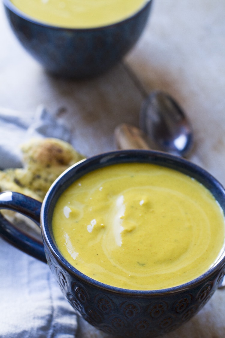 Butternut squash soup in a blue mug, without any topping.