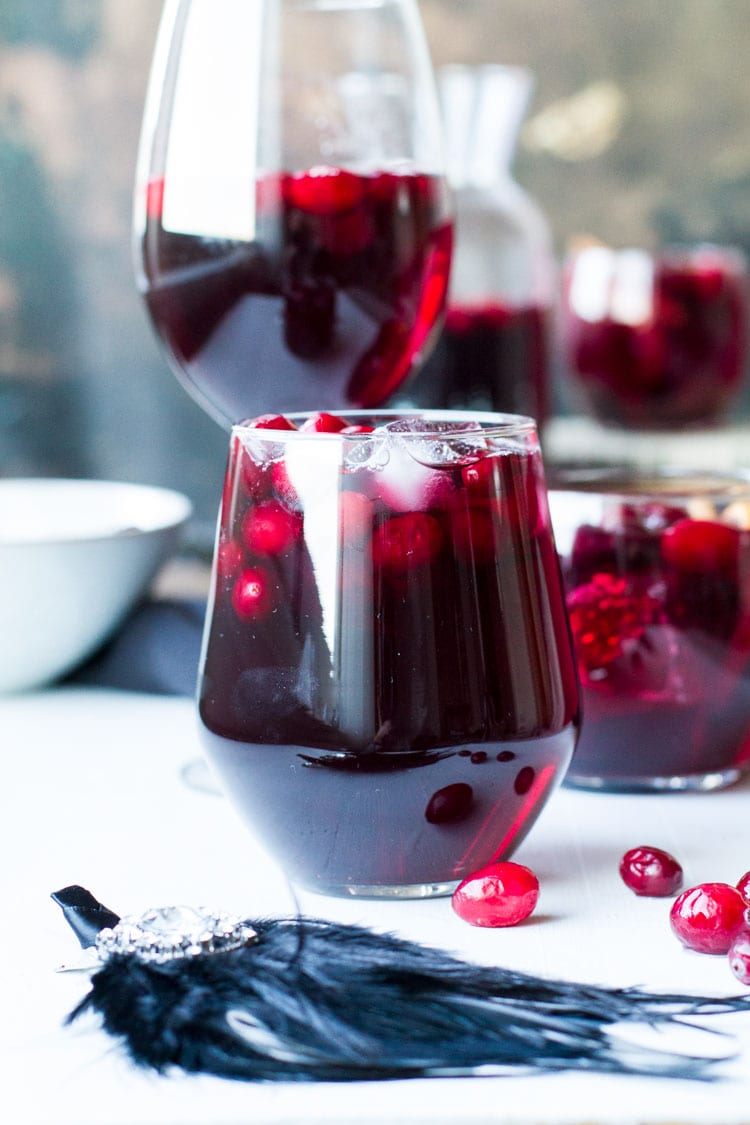 Stem-less wine glass with red wine and cranberries.
