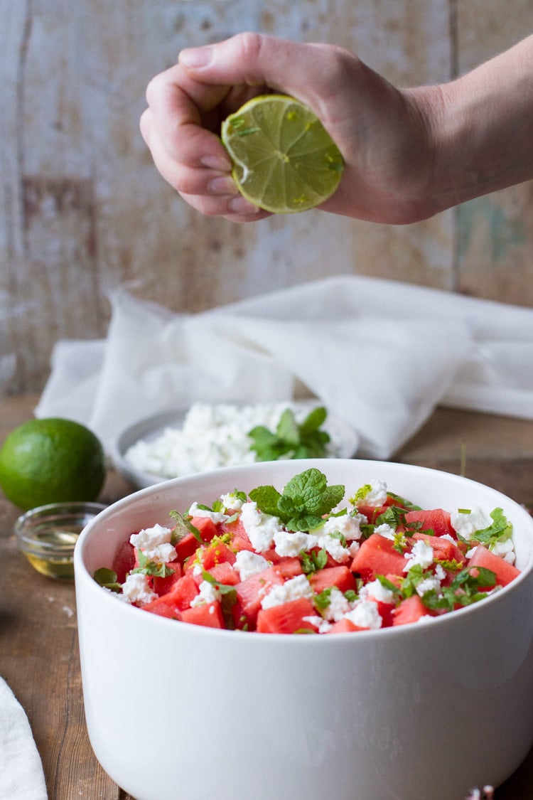Squeezing lime juice into watermelon salad.