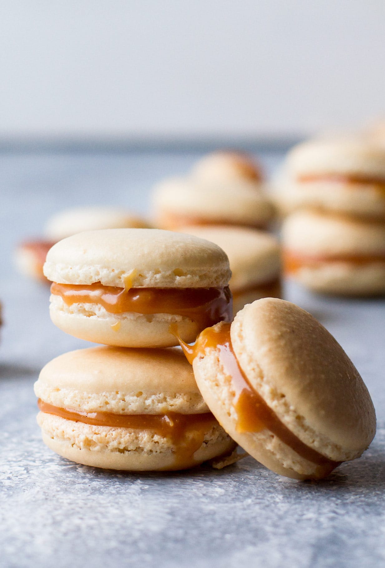 stacked salted caramel macarons with blurry background.