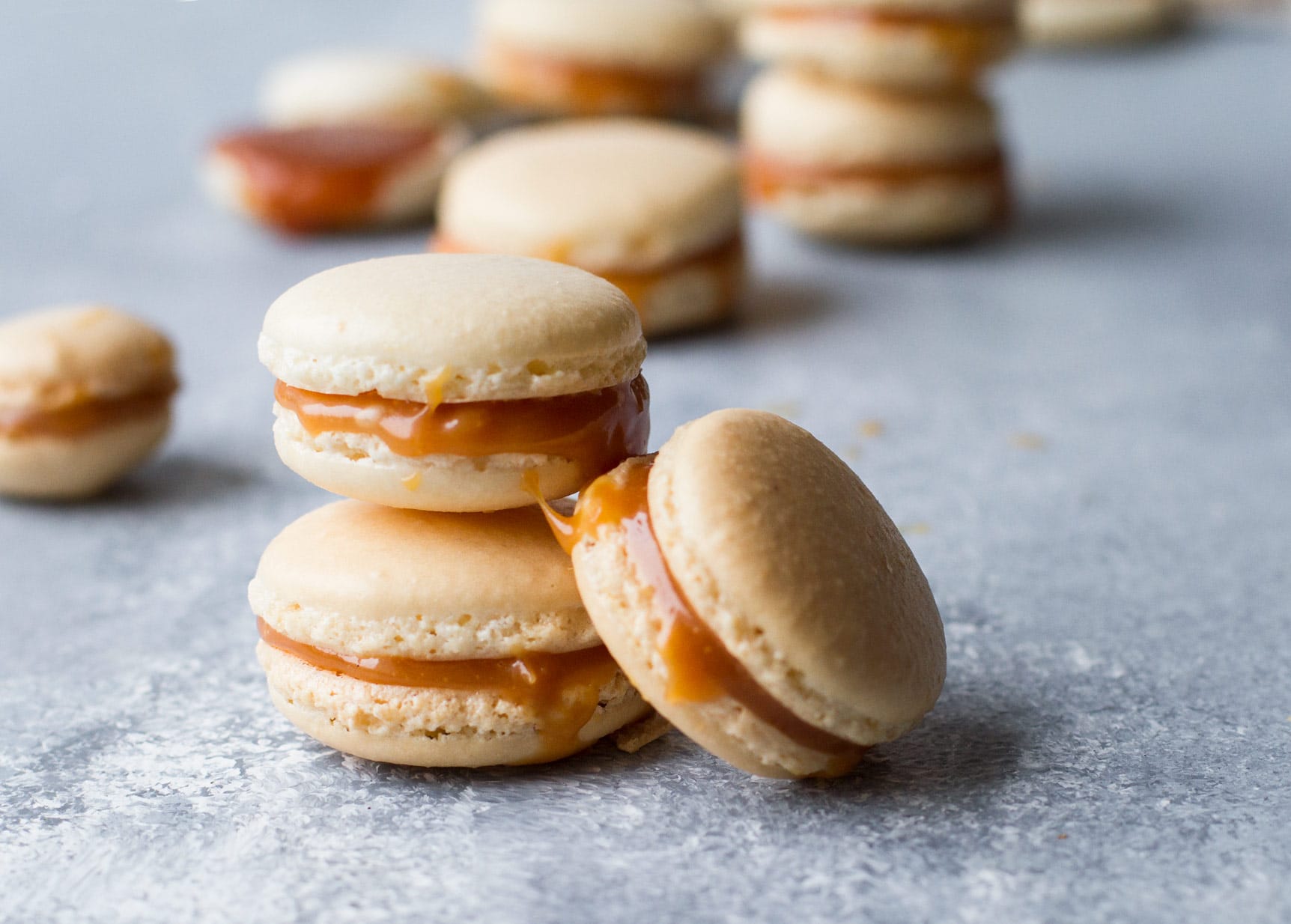 Salted Caramel Macarons with Homemade Caramel on blue background.