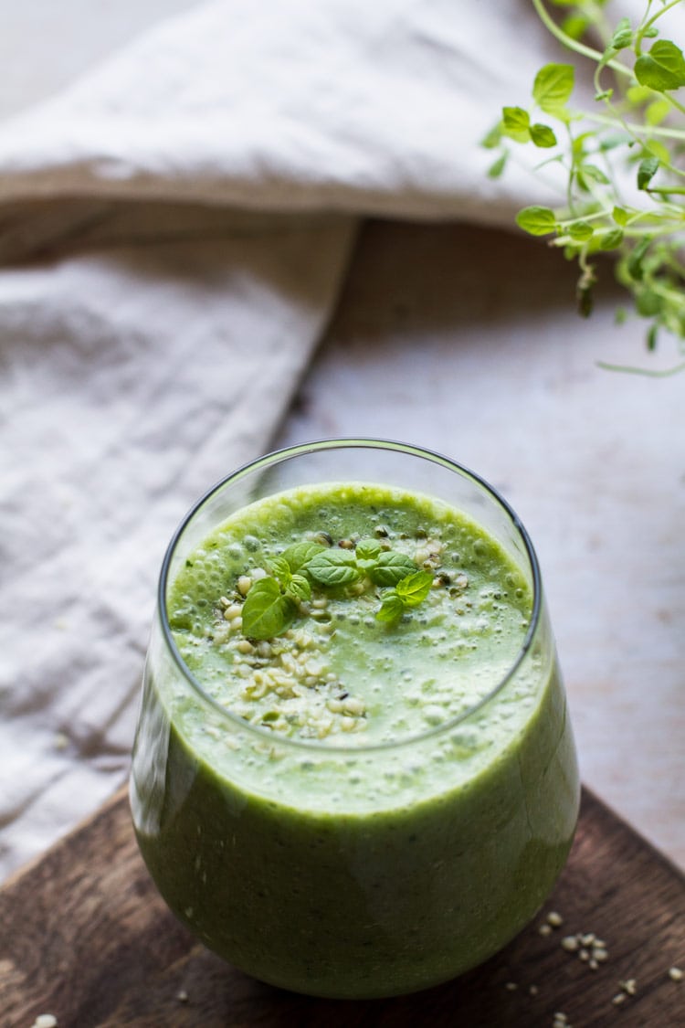 Photo of green smoothie recipe with focus on the texture of the smoothie. Beige tablecloth in the background.