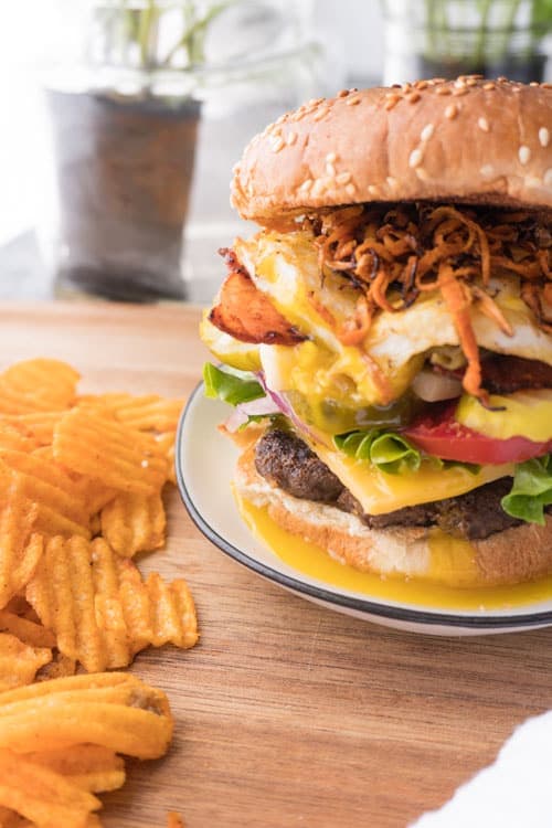 Burger filled with crispy onion, cheese, eggs, tomato.