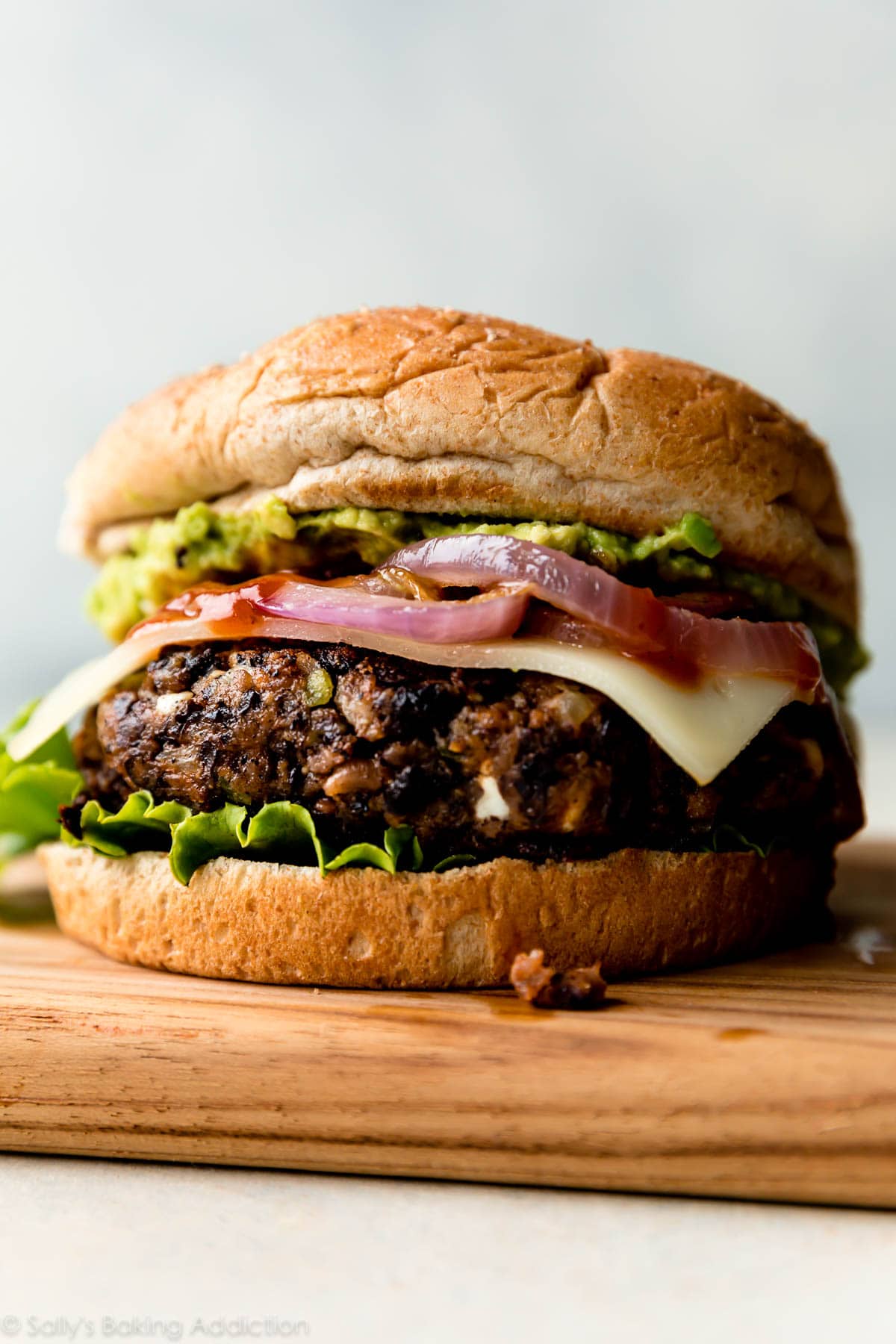 Black bean burger with guacamole and red onions.