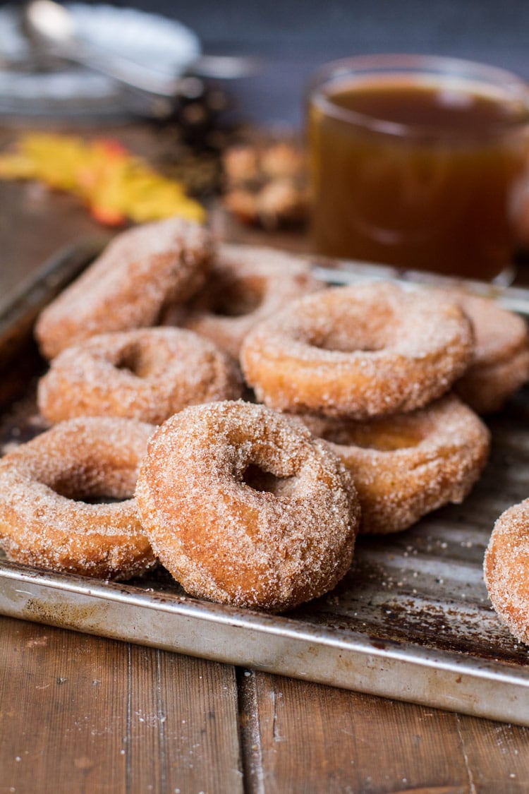Apple Cider Donuts coated in sugar and cinnamon on a metal pan.