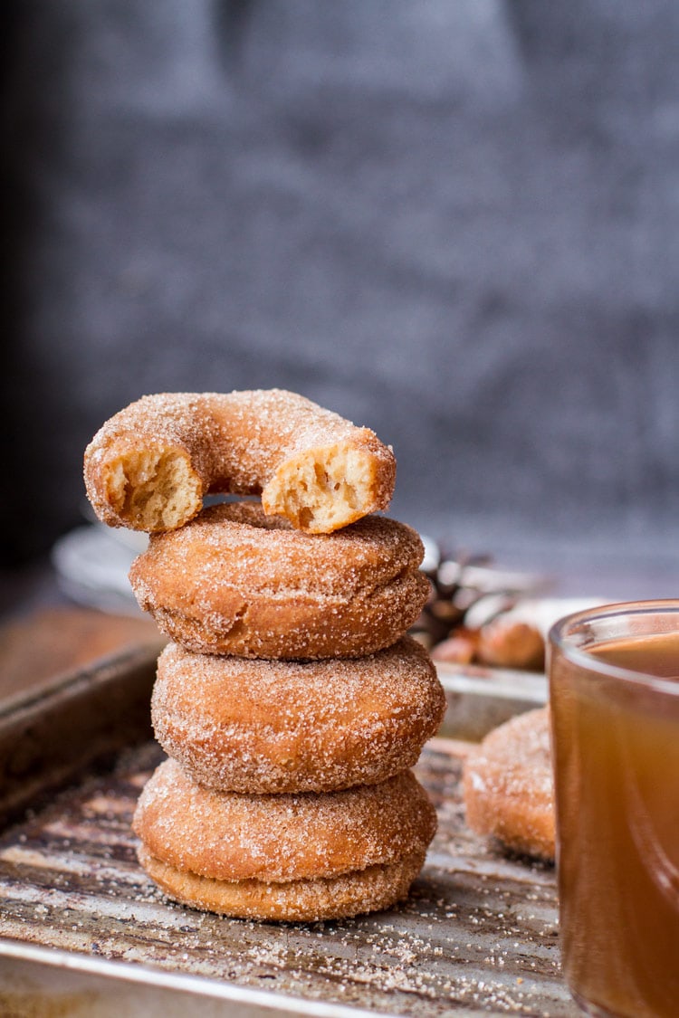 A stack of three apple cider donuts and one half on top. 