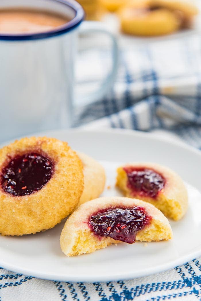 Classic thumbprint Christmas cookies, one open. Filled with raspberry jam.