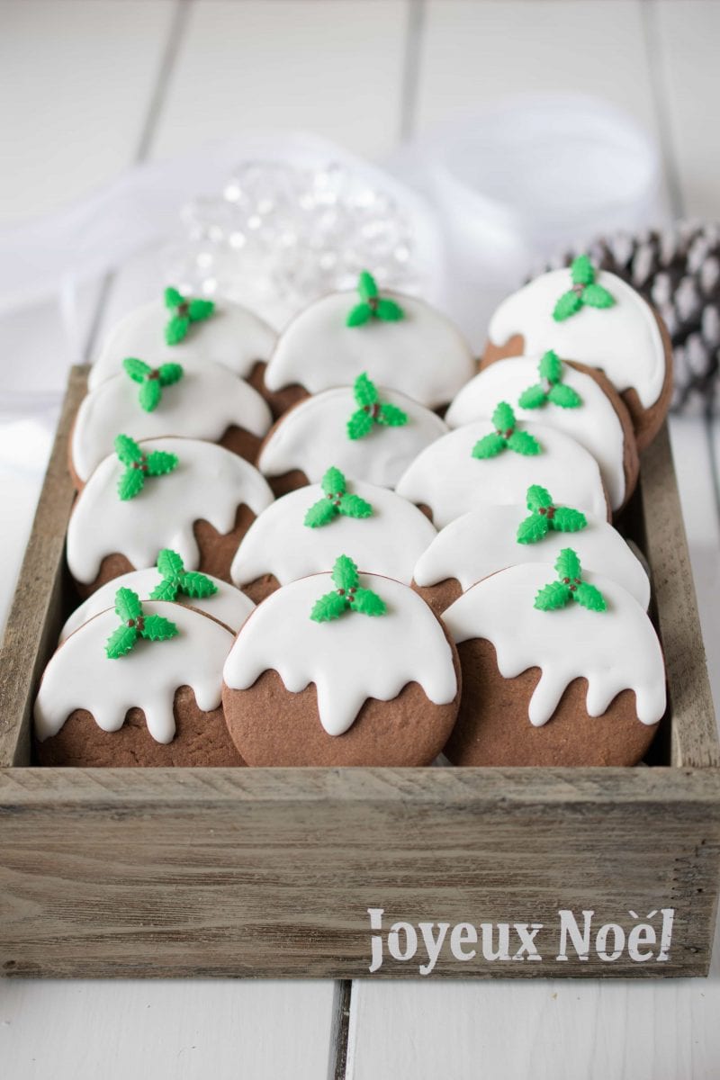 Round chocolate Christmas cookies with white icing and mistletoe decoration.