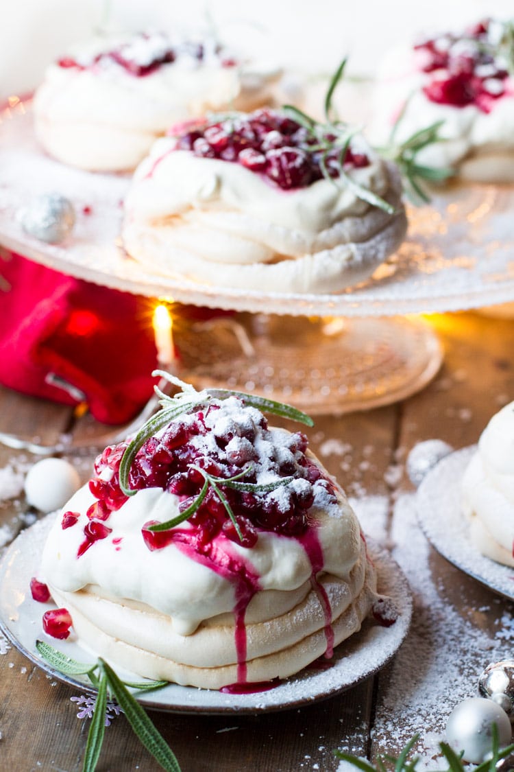 Christmas Pavlova Dessert with whipped eggnog cream and cherry sauce dripping down the sides. More in the background.
