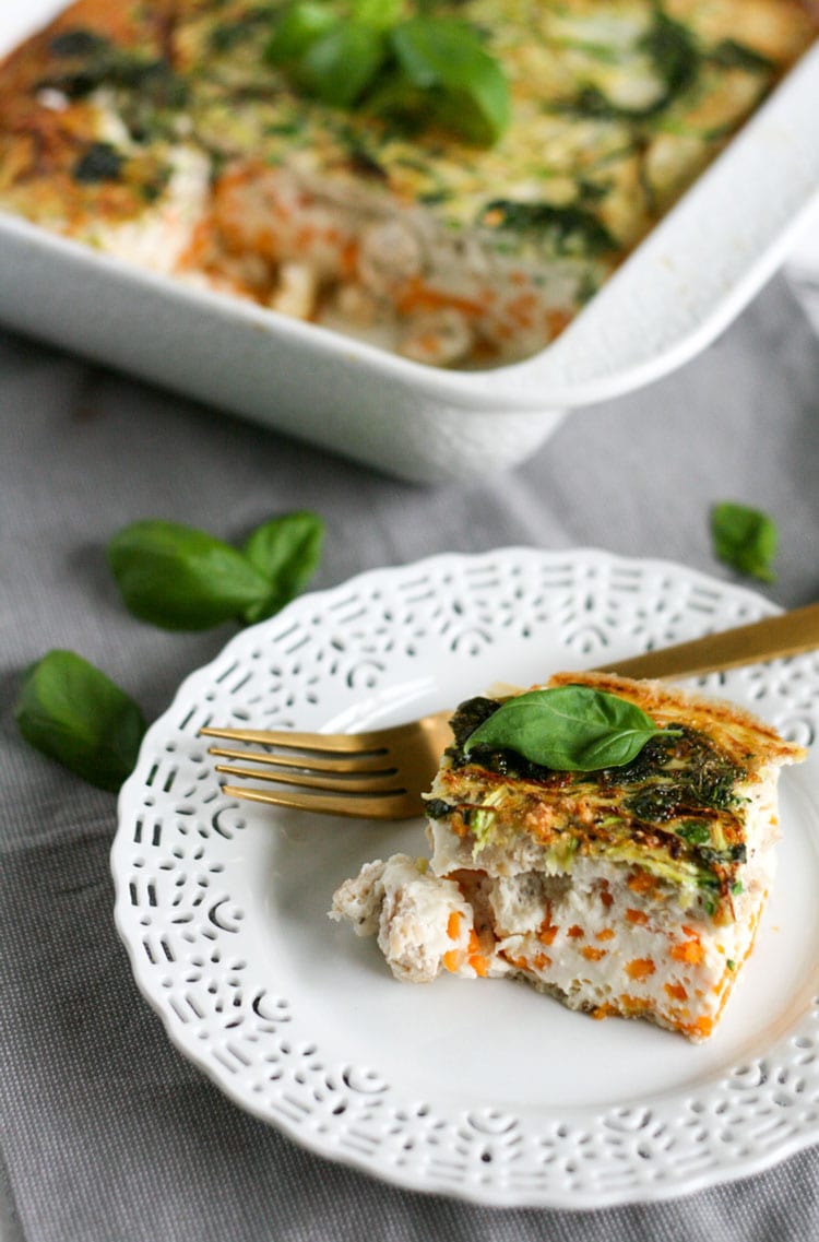 Healthy breakfast casserole on a white plate with golden fork.