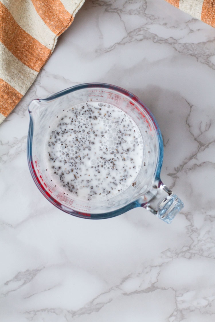 Coconut milk and chia seeds in a measuring cup.
