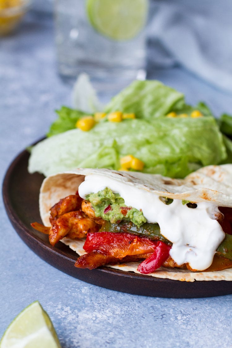 Serving suggestion for fajitas with tortillas, sour cream and guacamole.