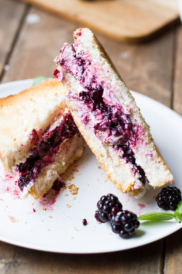 Cut open grilled cheese with blackberries inside.