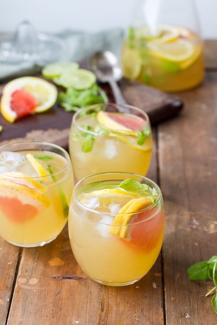 Three glasses with iced tea and grapefruit wedges.