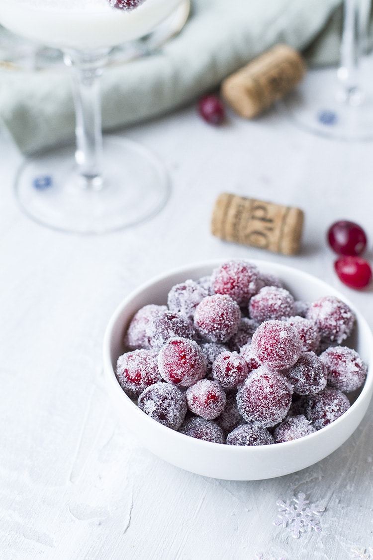 A small white bowl with sugared cranberries.